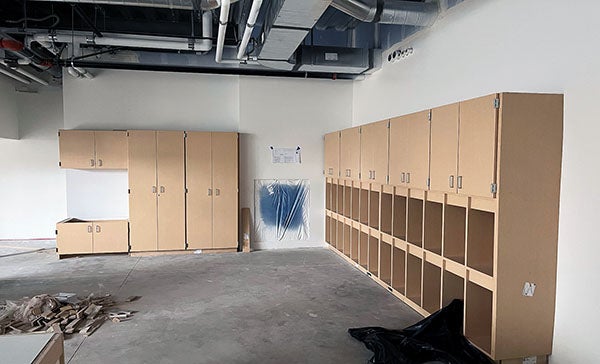 a large room with no ceiling has cabinets on two walls
