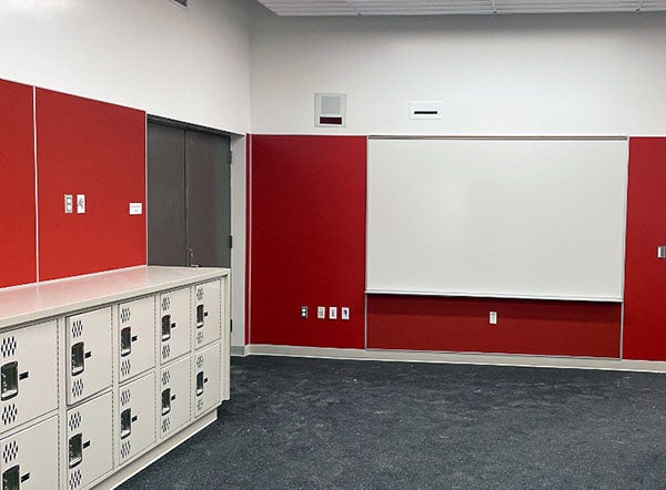 white board and low lockers in a room with red walls