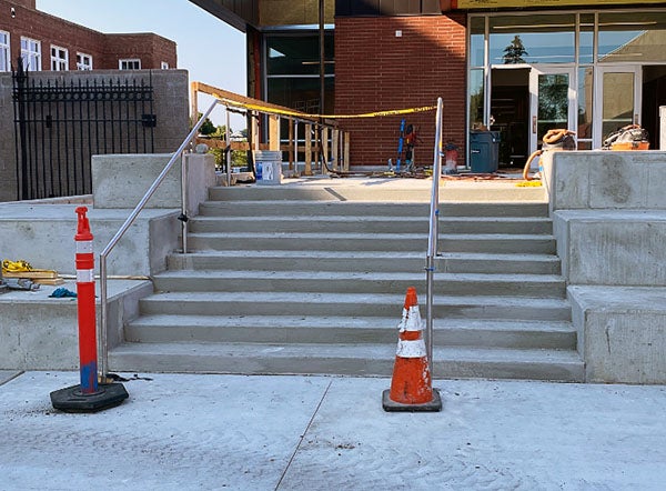 concrete exterior stairs with metal railings