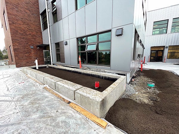 a brick and metal clas building with a concrete planter