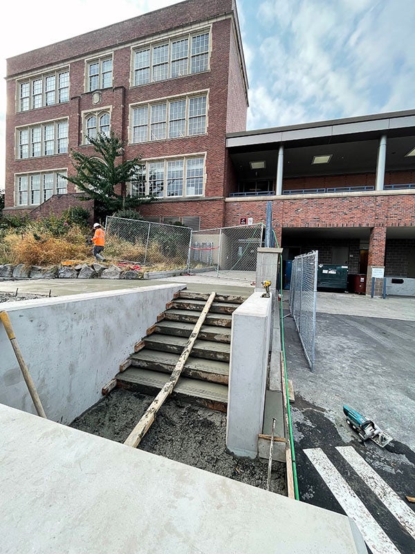 fresh concrete poured for exterior stairs in front of a brick building