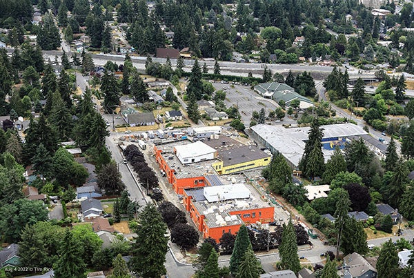 aerial photo of a building under construction with trees and house around it