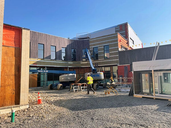 an exterior of a building under construction with a curved 2-story wall
