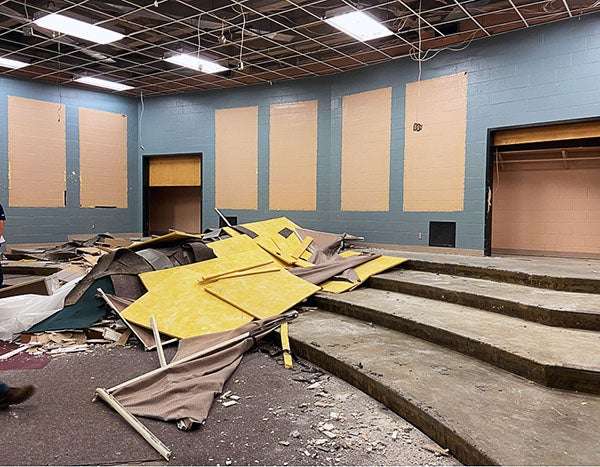 a large room with risers has construction debris in the center