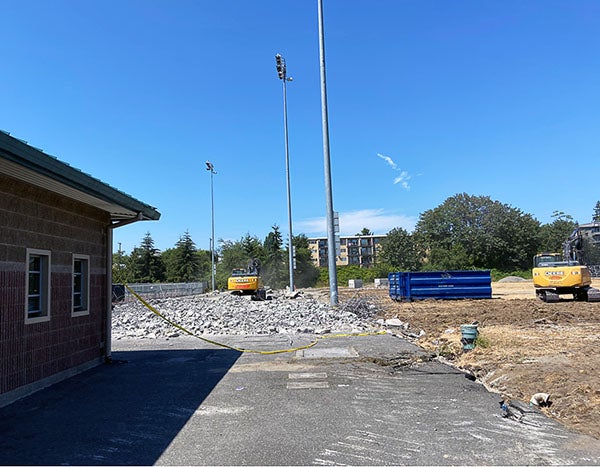 a small building inf ront of construction debris and light poles