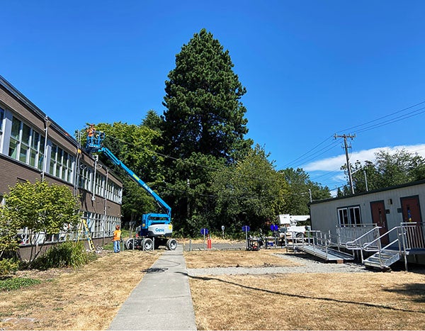 a two story building with a lift across from a portable