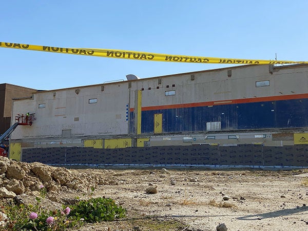 a large concrete building has weather proofing material on it