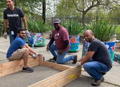 Four men work on a project on a school playground