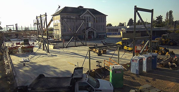 a 3-story historic school house sits amidst construction activities