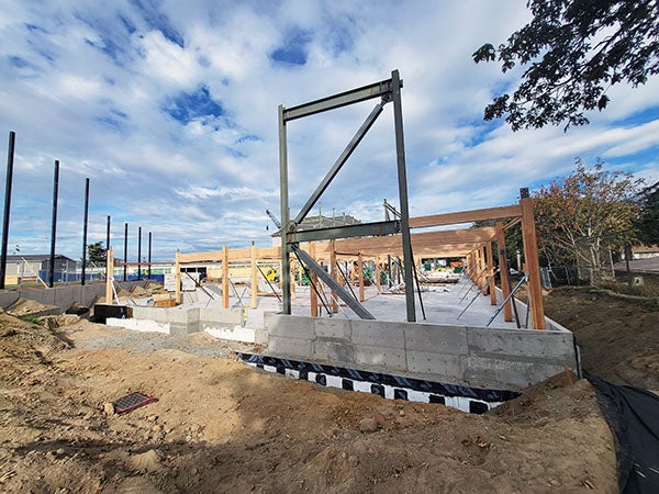 a concrete foundation has glulam beams and structural steel installed