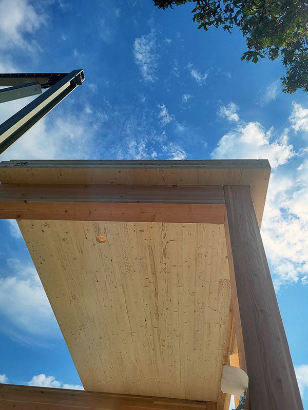 a cross-laminated timber panel rests on glulam wood framing