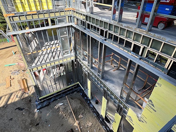 a three story building under construction with metal studs going up