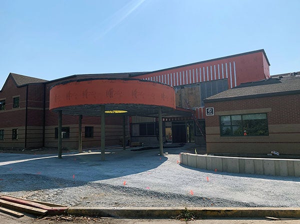 part of a 2 story building with weather wrap on the upper part and around a circular canopy