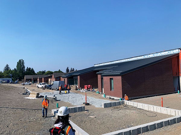 a one story brick building with construction work happening on the ground in front of it