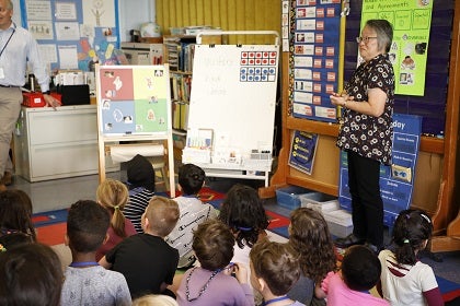 A teacher stands before a classroom of students