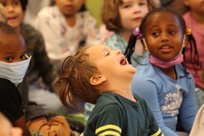 A young student laughs while sitting together with classmates