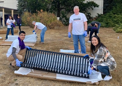 Volunteers place a new bench on school grounds