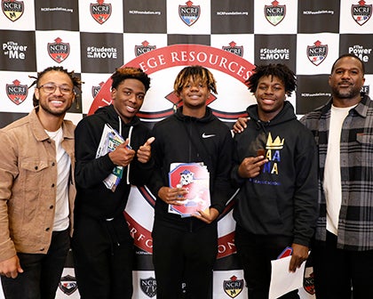 A group of five men stand together at the expo event