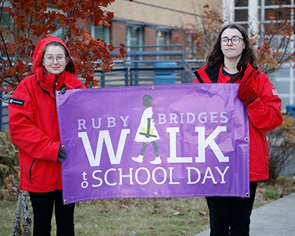 Two students hold up a banner that says "Ruby Bridges Walk to School Day"