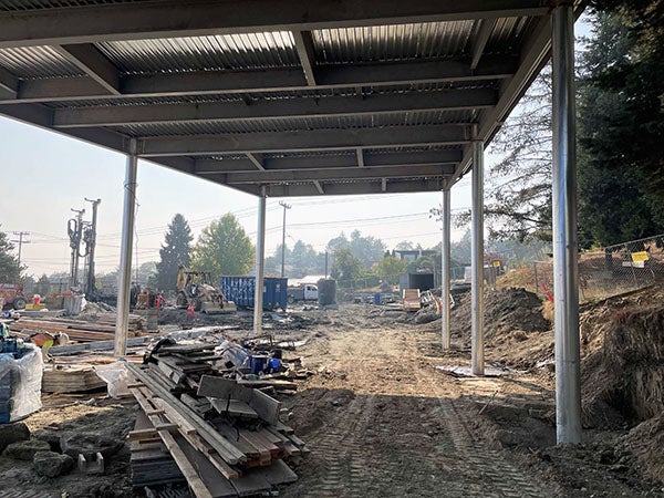 a metal roof supported by posts with construction stuff piled under it
