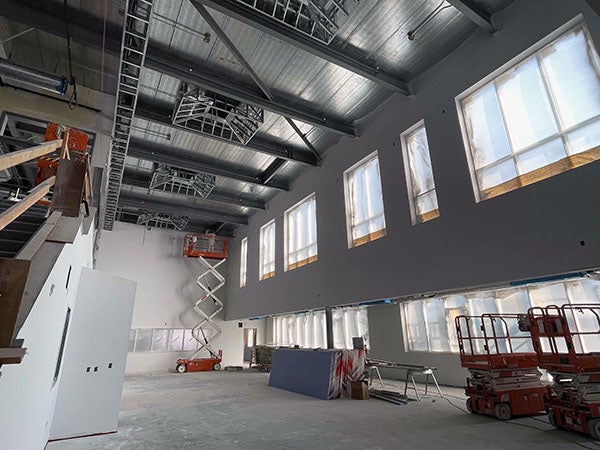 a large open space with windows and high ceilings under constructino