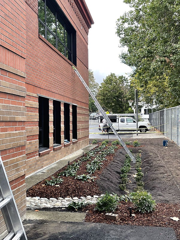 a brick building with a partially planted garden