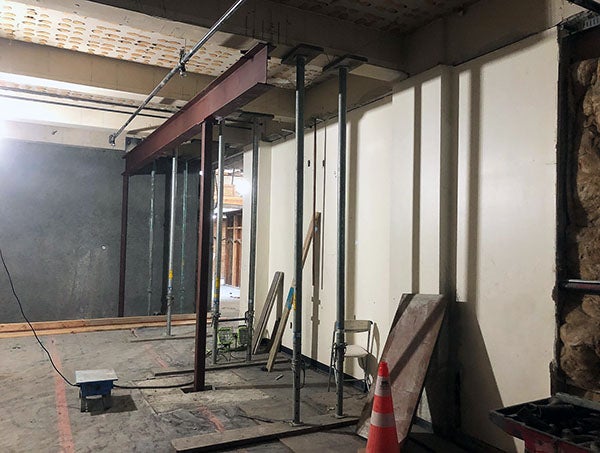 an indoor space under construction with steel posts and a steel beam