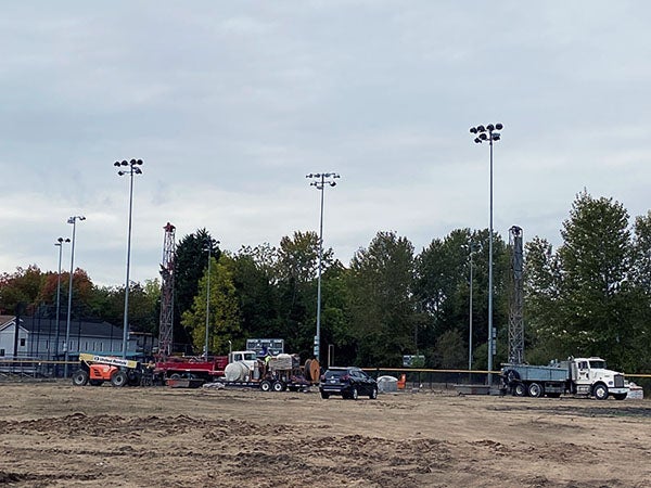 trucks in a dirt field with light poles