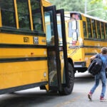 Students getting off a yellow school bus