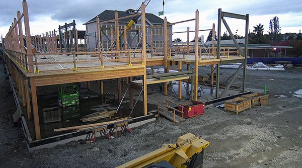 a structure is under construction with a historic building in the background