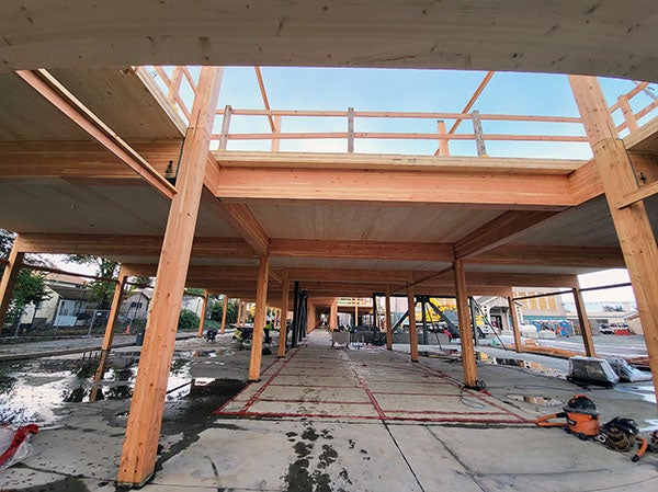 a building under construction with wood columns and decking