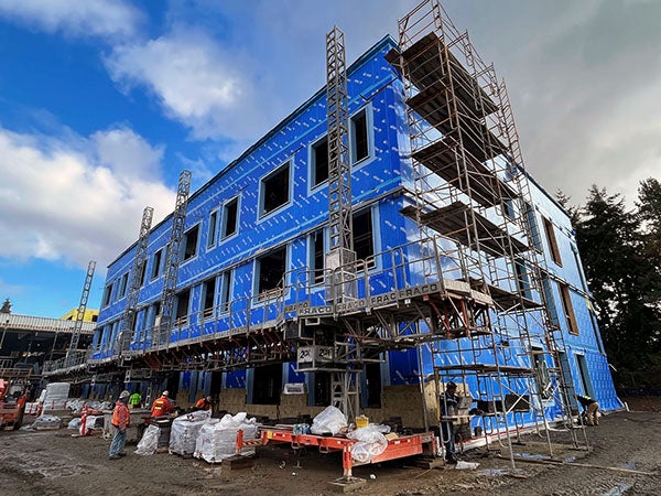 a 3-story building under construction with brick being put on the bottom level