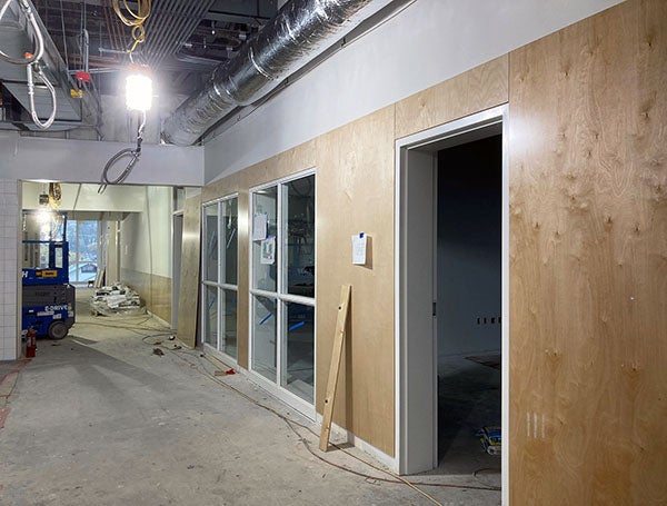 an unfinished hallway with wood paneling on walls