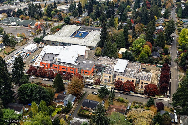 Aerial view of a large building surrounded by houses and trees
