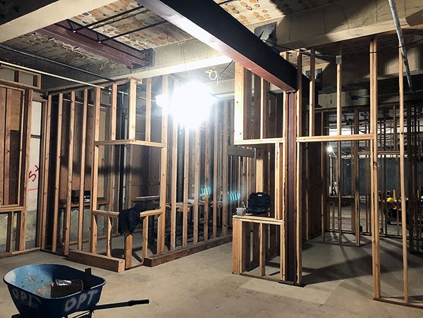 an interior of a building under construction with wood framing and a structural steel beam