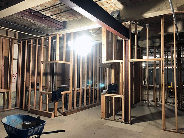 an interior of a building under construction with wood framing and a structural steel beam