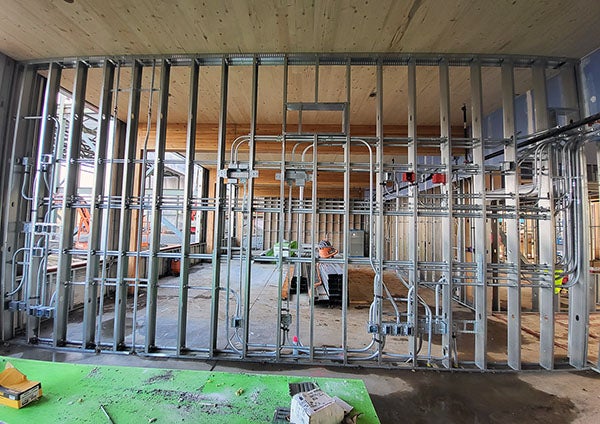 interior of a building under construction with metal studs and electrical conduit
