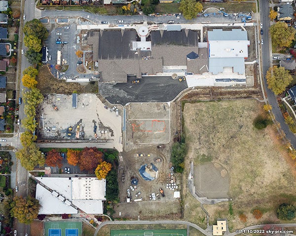 aerial view of a large building with asphalt and paving