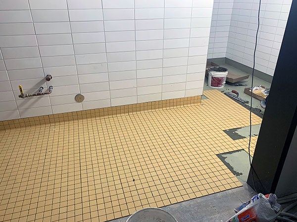white ceramic tile on walls and yellow ceramic tiles on floor