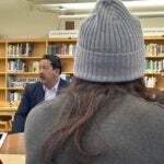 Superintendent Jones, Mayor Harrell, and Governor Inslee talk with students in the school library.