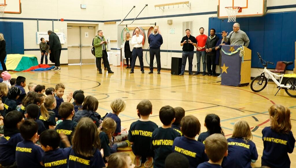 Governor Inslee addresses a gym full of students and teachers at Hawthorne