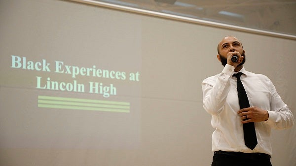 A student talks at a school assembly