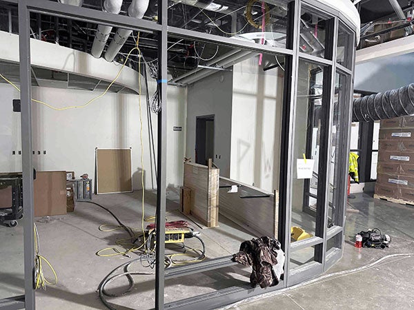 a curved metal fram has windows in some of the spaces and waits for others to be installed