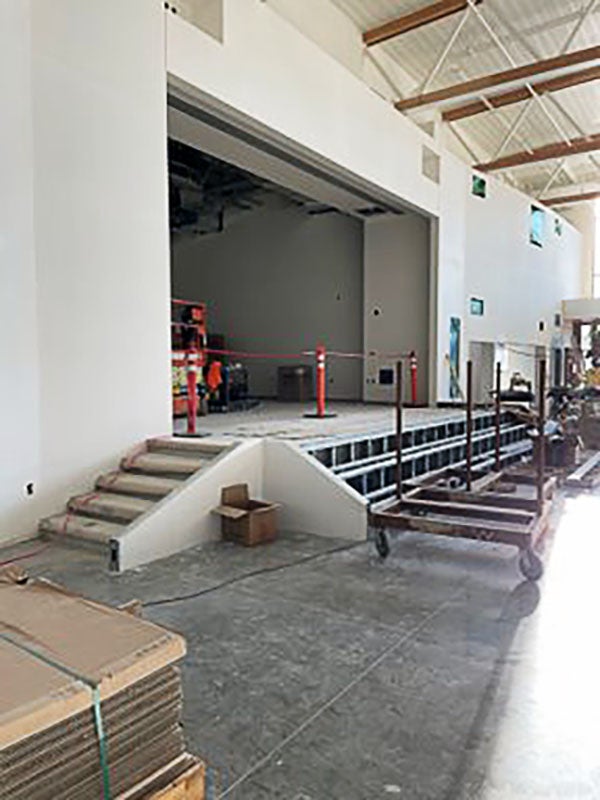 a stage with stairs being built across the front within a large open room