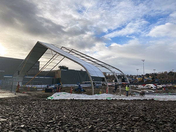 a large frame work is being installed over an area with large rocks