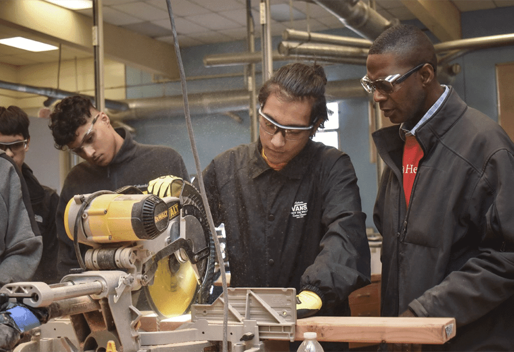 Students anda mentor wroking in a wood shop