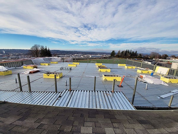 a meal roof has yellow boxes and a railing