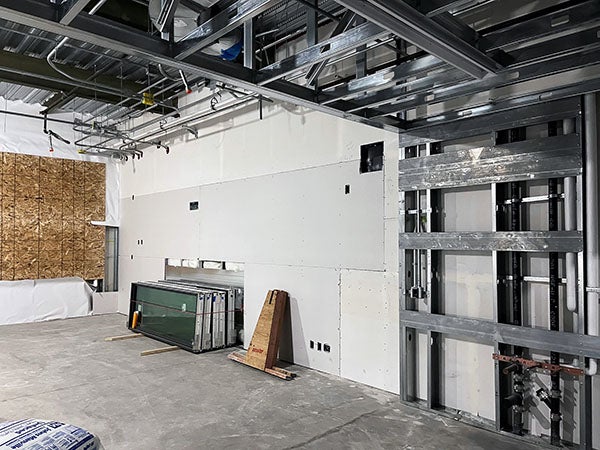 a partially completed room with wallboard that is not taped and a chipboard panel on one wall