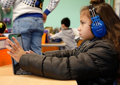 A student works on a laptop in a classroom