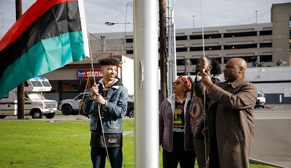 Superintendent Jones and community members raise the Pan African flag